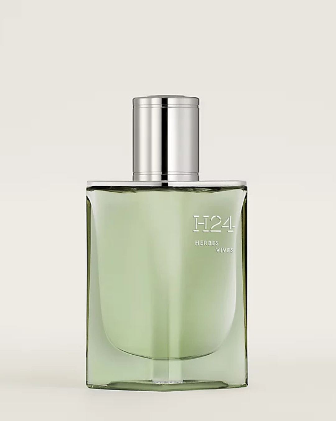 Green perfume bottle labeled 'H24' by Hermes on a light gray background