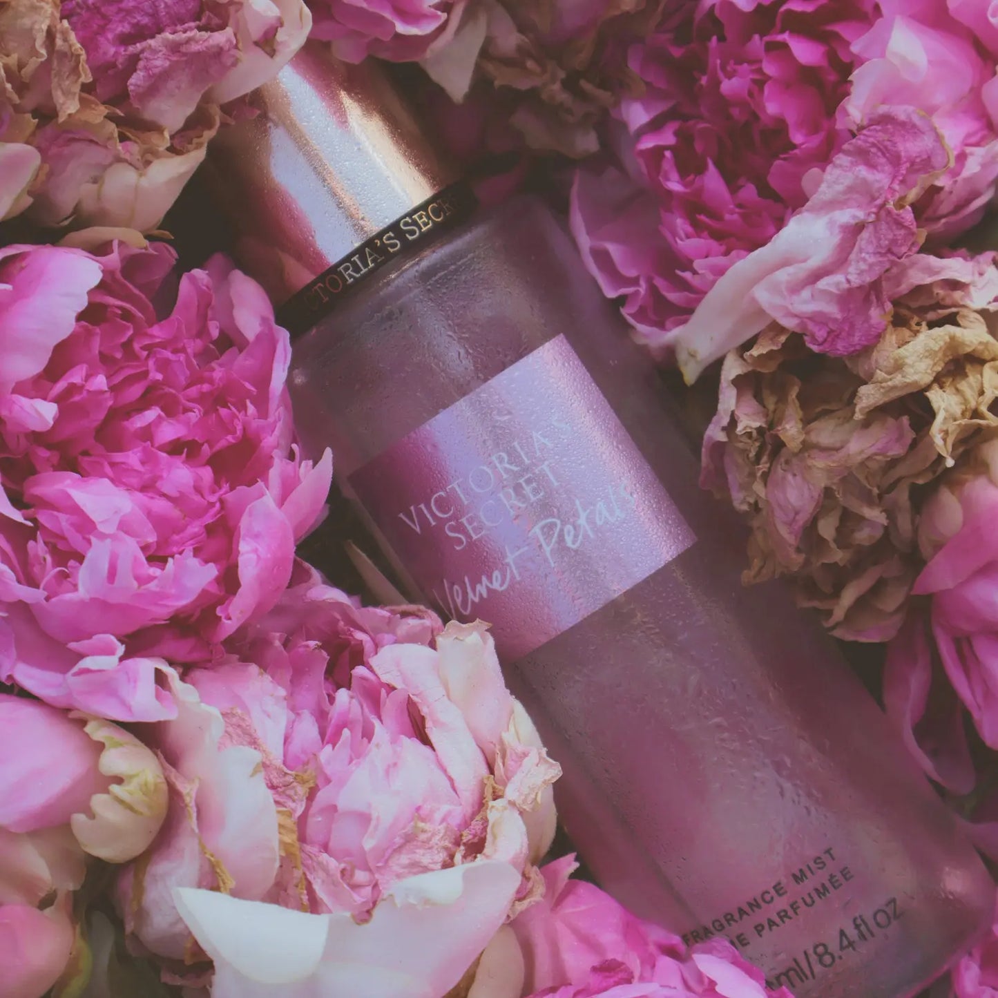 Victoria's Secret perfume bottle surrounded by pink flowers