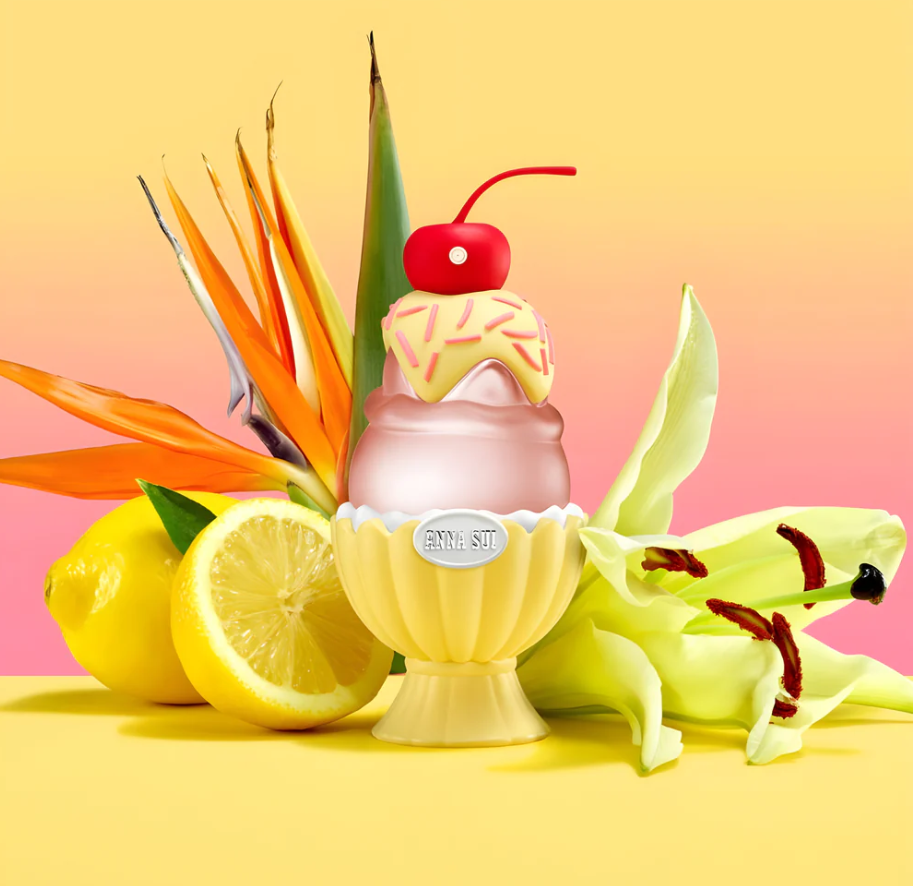 perfume with cherry and sprinkles on a yellow background with lemons and flowers