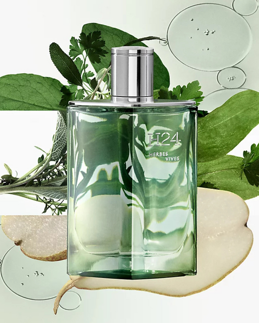 Green perfume bottle with silver cap on a natural background with leaves and stones.