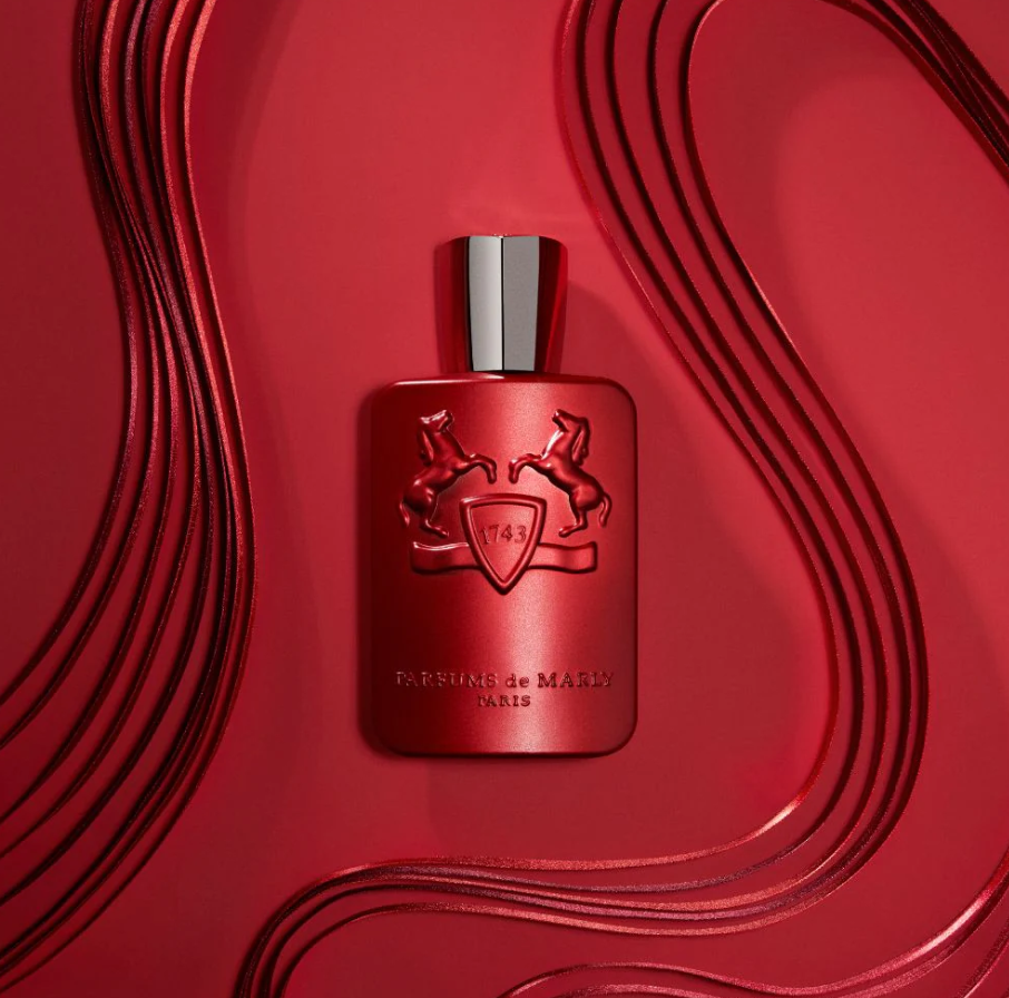 Red perfume bottle with a silver cap on a red background