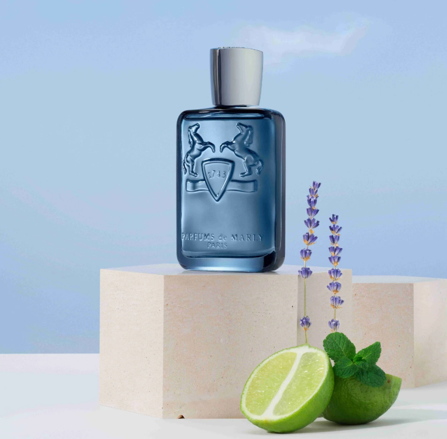Blue perfume bottle with lavender and limes on a light background