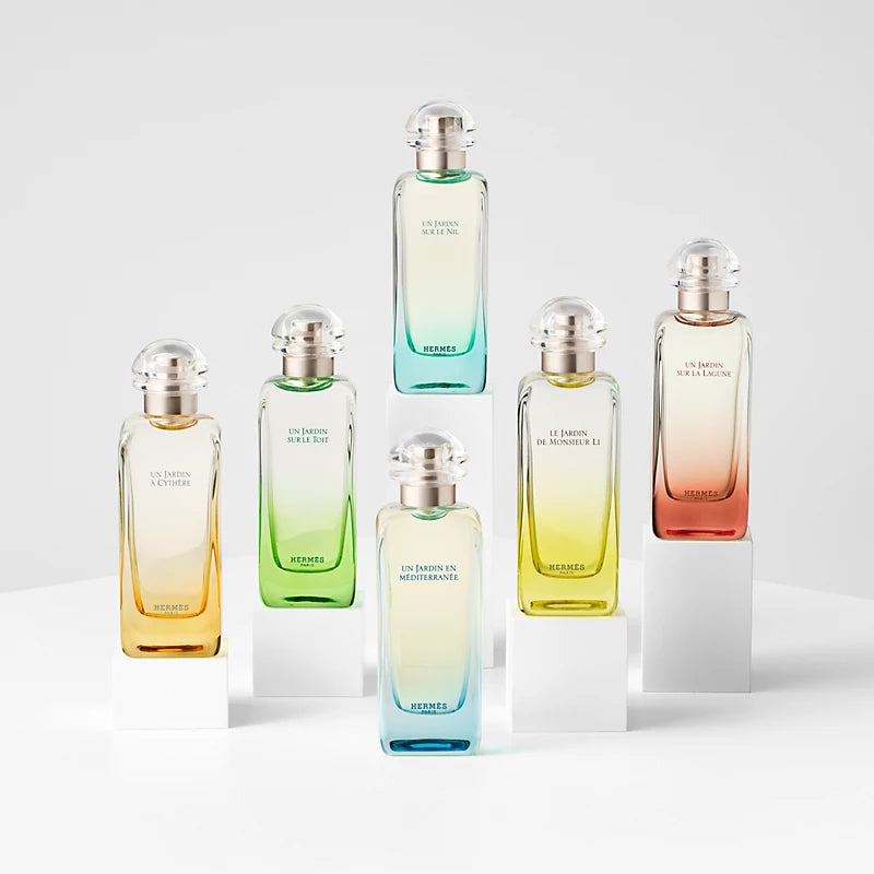 Set of Hermes perfume bottles in various colors on a white background