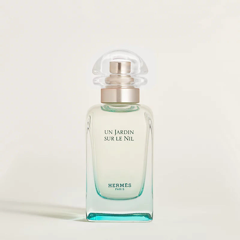 Hermes perfume bottle with a light green shade on a beige background