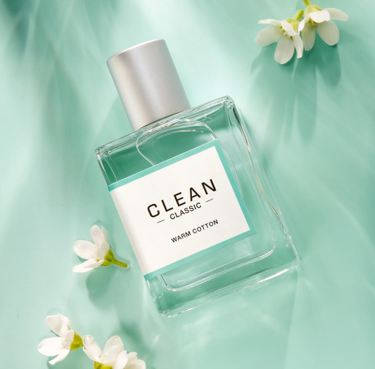 Perfume bottle labeled 'Clean' with white flowers on a light green background
