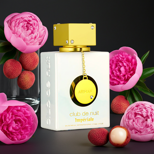 Perfume bottle with gold cap and pink flowers on a dark background