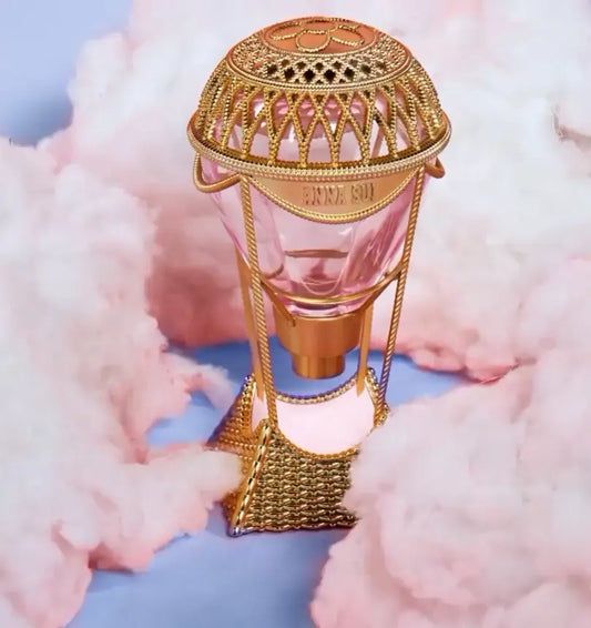 Decorative perfume with gold and pink design on a blue background
