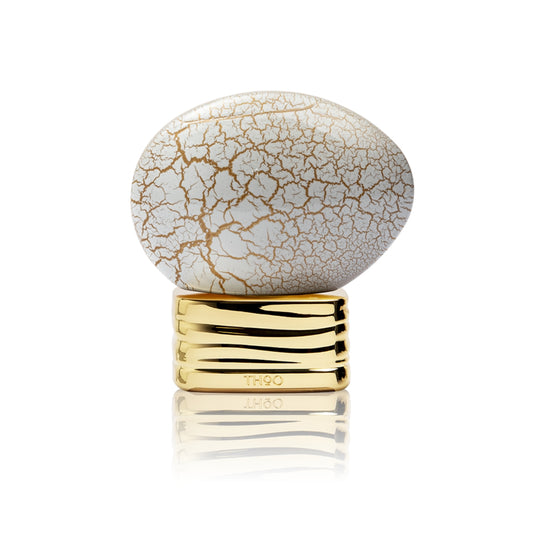 Decorative object with cracked white surface and gold base on a white background