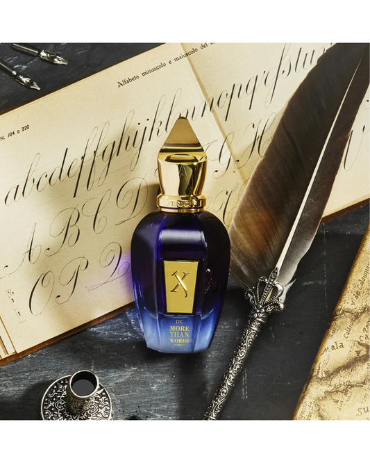 Blue perfume bottle with gold cap on an open book with quill and map