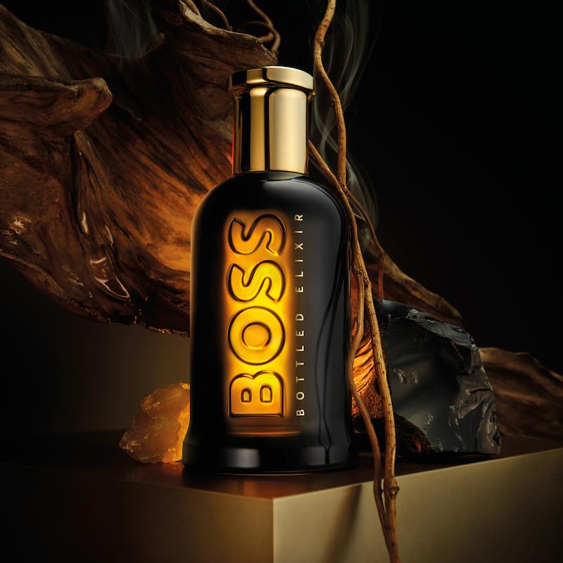 BOSS Bottled Elixir perfume bottle with gold cap on a dark background