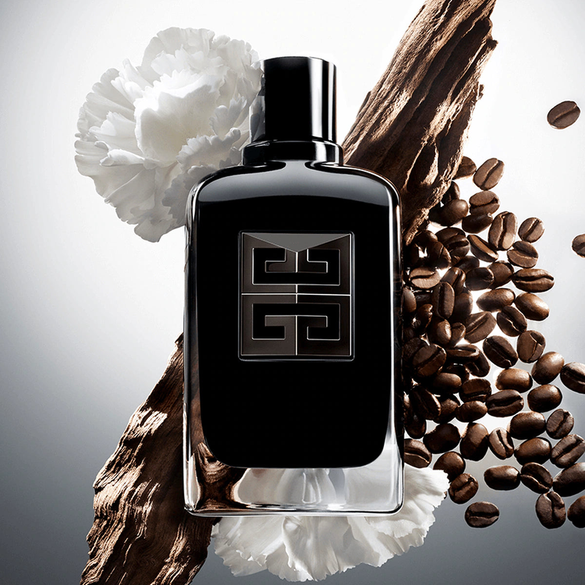 Black perfume bottle with a logo surrounded by coffee beans and a white flower on a gray background