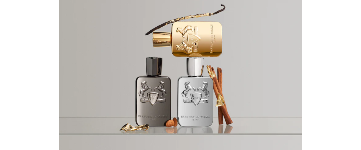 Three perfume bottles with gold, silver, and bronze caps on a light gray background