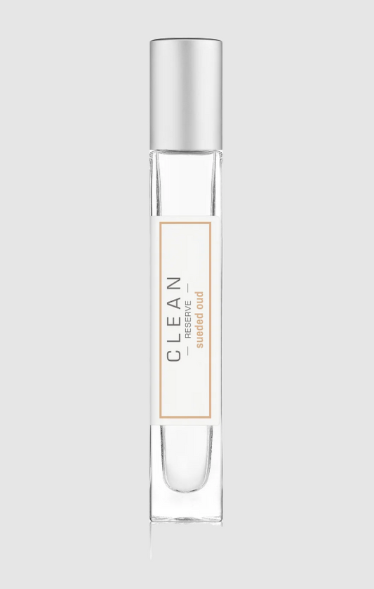 Clear perfume bottle with silver cap on a light gray background