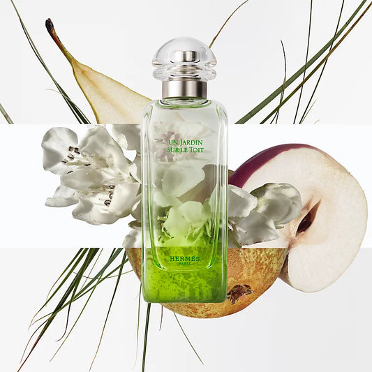 Hermes perfume bottle with flowers and fruit on a light background